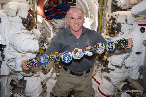 Jeff Williams pictured inside the Station's Quest Airlock with patches from his previous flights to Space - Photo: NASA