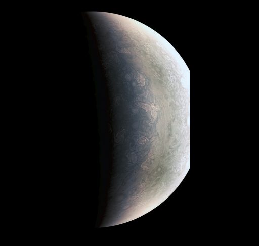 This enhanced photo of Jupiter's north pole, taken from a distance of 78,000km, brings out a boundary between the grayish region closer to the pole (left) and a lighter-toned area to the south. This boundary may be the result of a different in temperature between the atmospheric zone near the pole and toward the equator. The darker region near the pole is littered with storms that will a focus of Juno's scientific mission. - Credit: NASA/JPL-Caltech/SwRI/MSSS